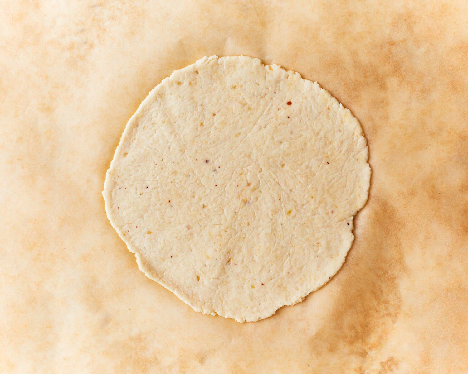 Almond flour tortilla dough rolled onto parchment paper.