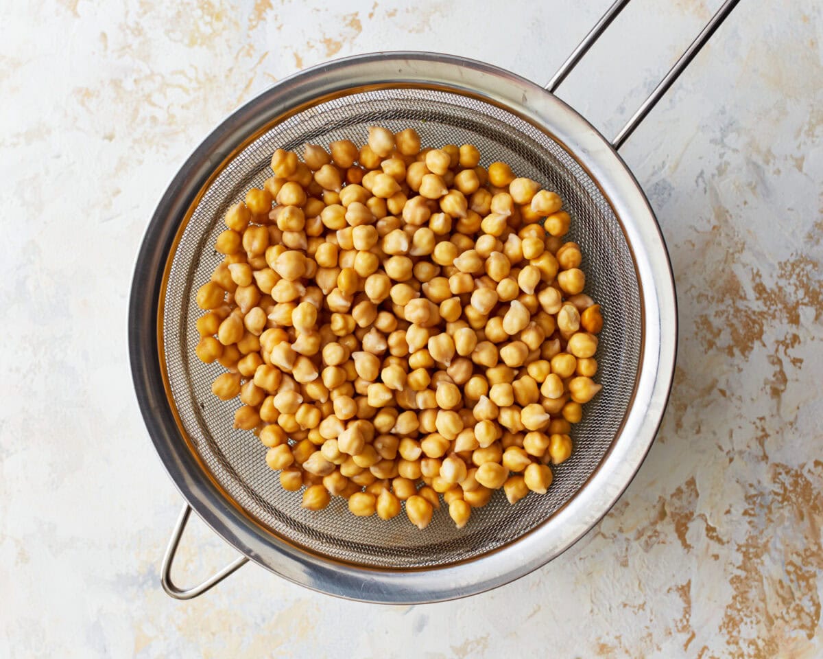 draining soaked chickpeas in a colander.