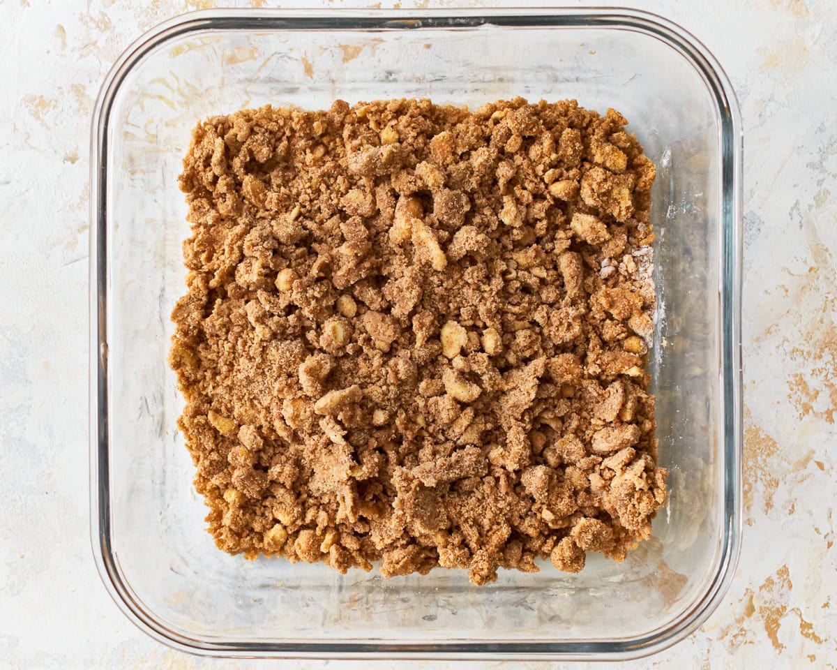 The crisp for gluten-free peach crisp in a glass baking dish.