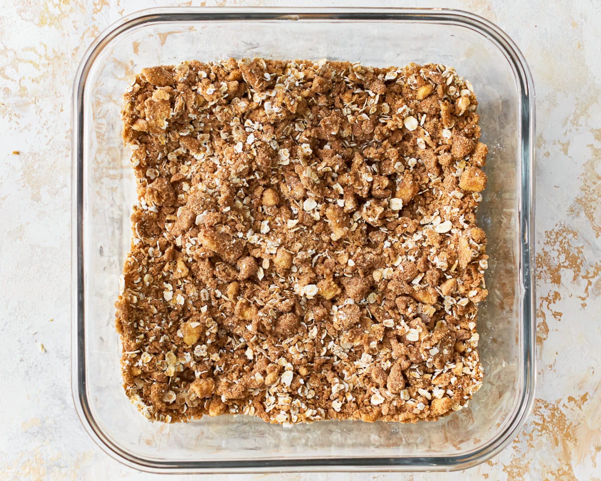 Oats mixed into the crisp for gluten-free peach crisp in a glass baking dish.