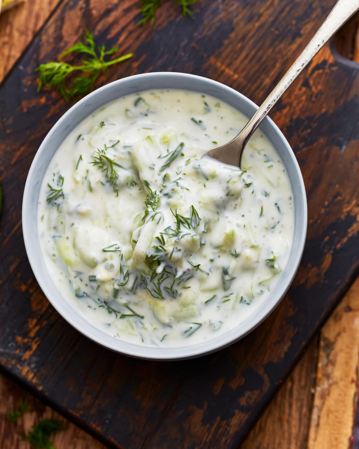 A fork taking some dairy-free tzatziki from a bowl.