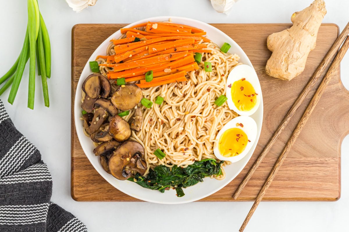 Gluten-free ramen in a large bowl on a wooden chopping board