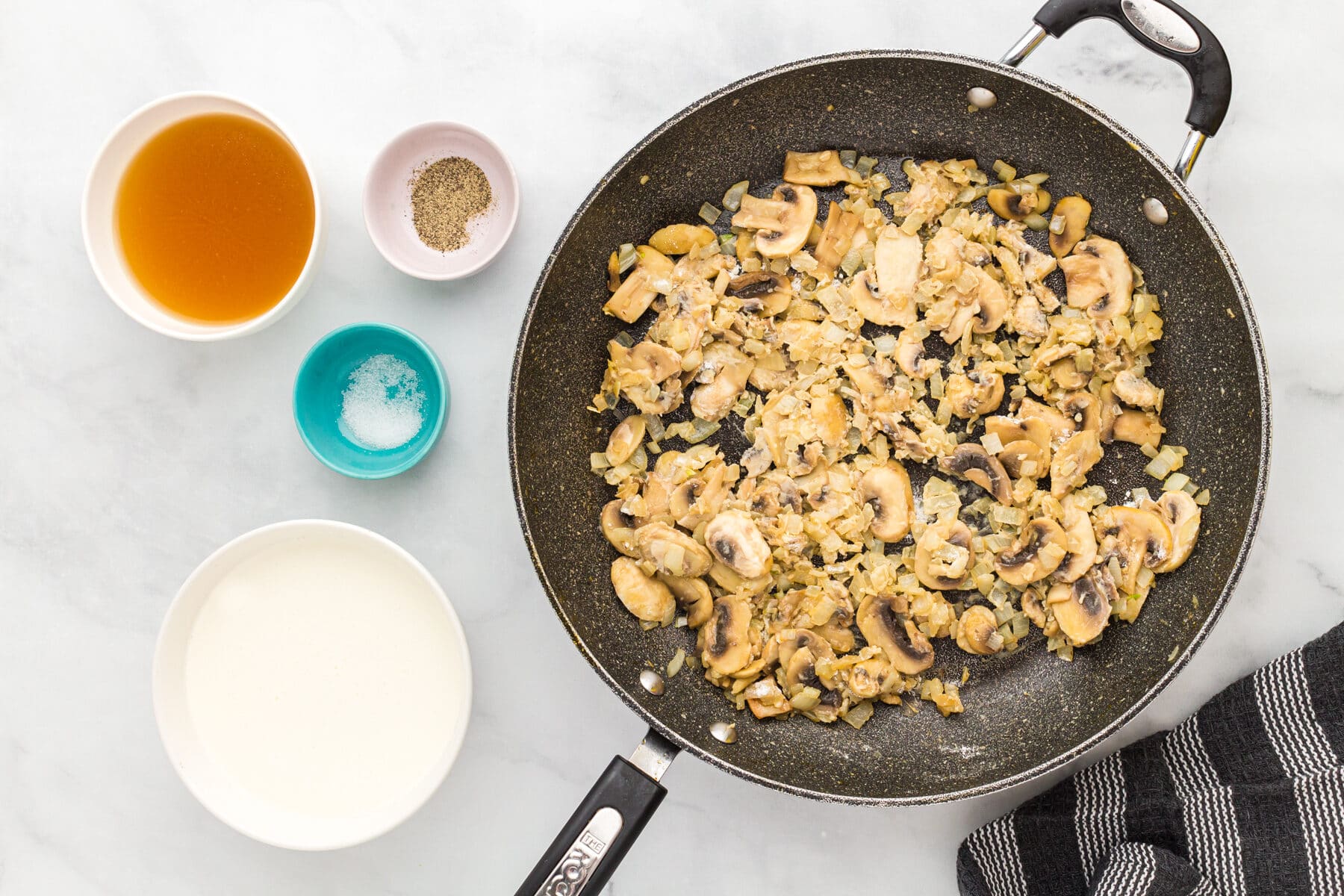 Mushrooms and onions coated in gluten-free flour in a skillet for the filling for gluten-free tuna casserole