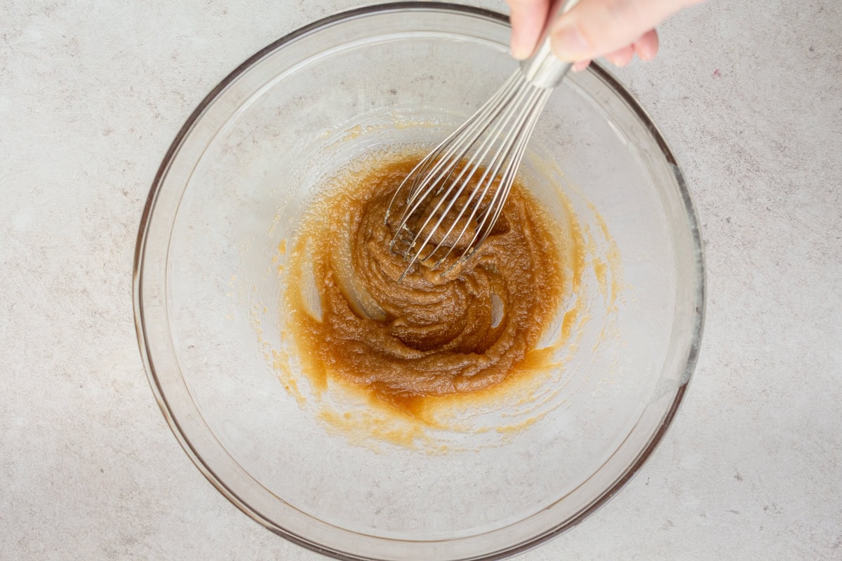 Brown sugar and butter whisked together in a glass mixing bowl