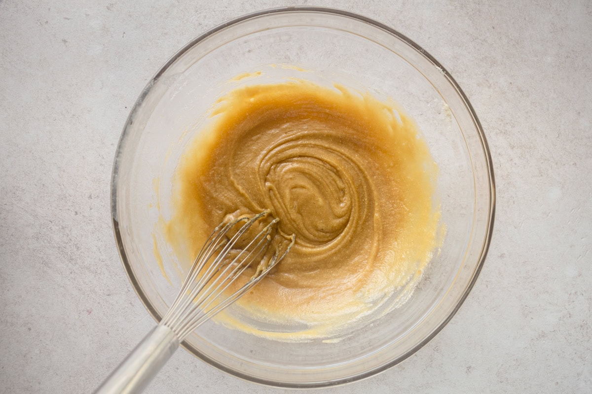 The wet ingredients for coconut flour chocolate chip cookies in a glass mixing bowl