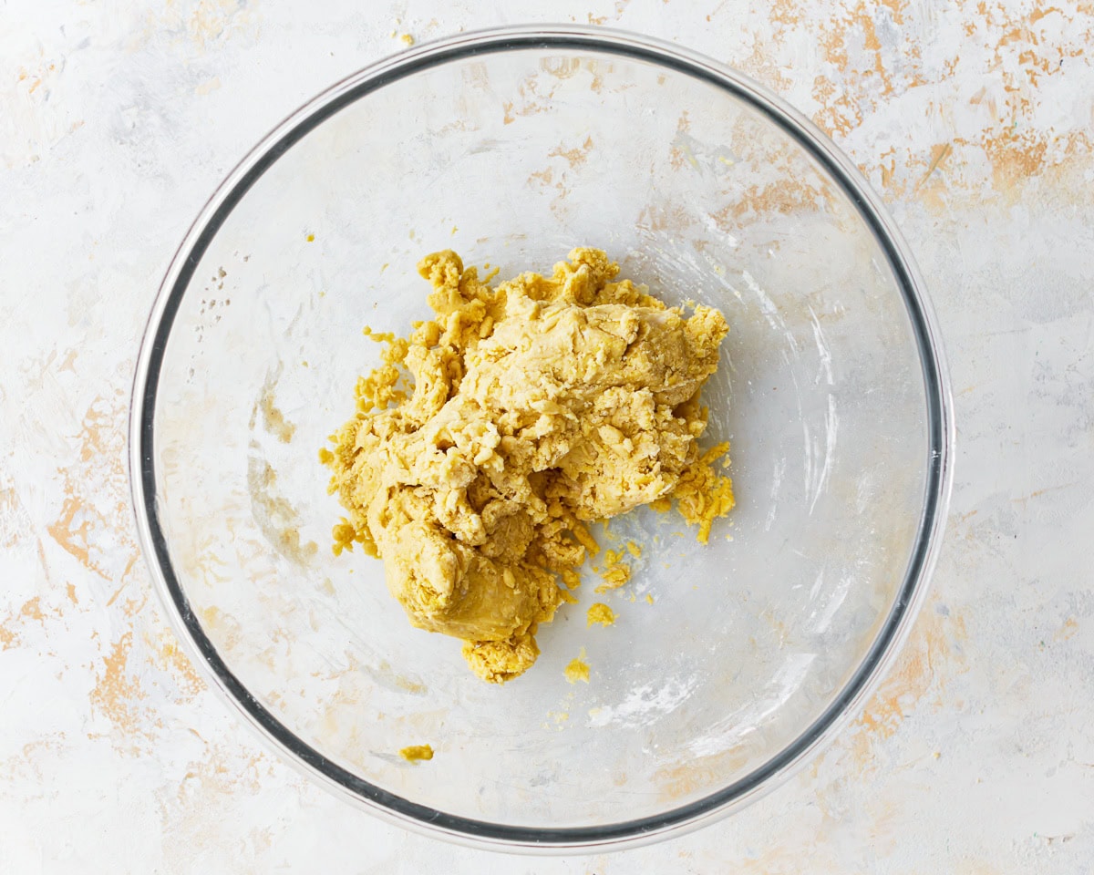 Shaggy dough for gluten-free egg noodles in a glass mixing bowl