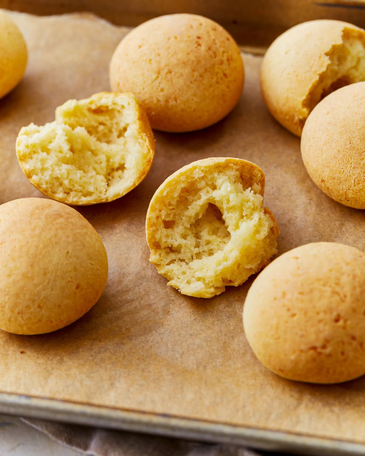 Pandebono Colombian cheese bread on a parchment lined baking sheet