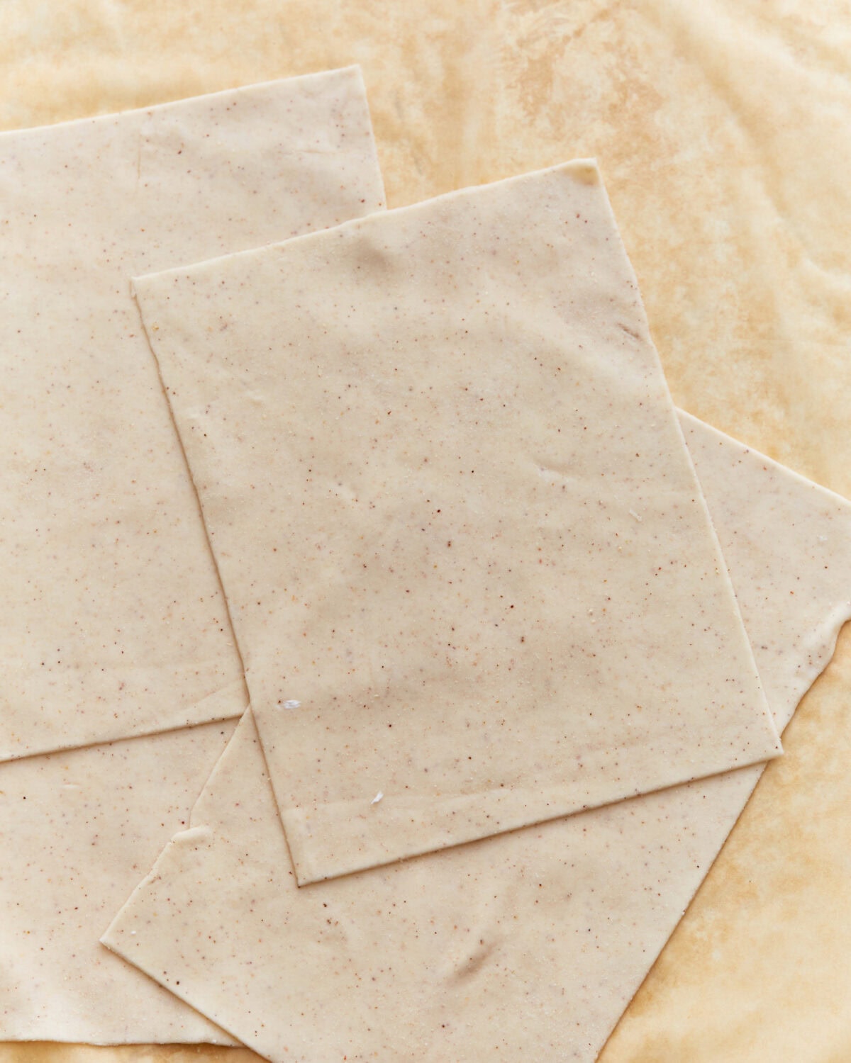 Sheets of gluten-free phyllo dough on a parchment paper.