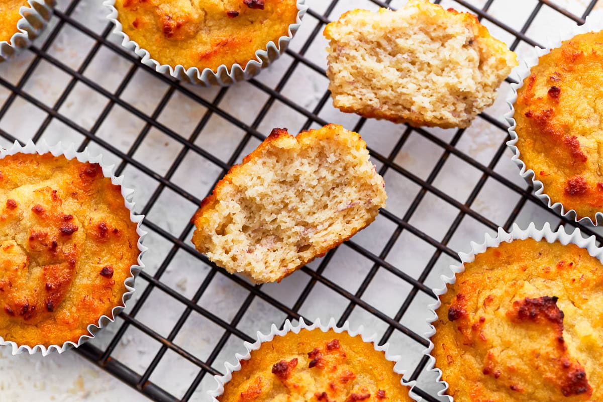 A coconut flour muffin broken in half on a cooling rack.