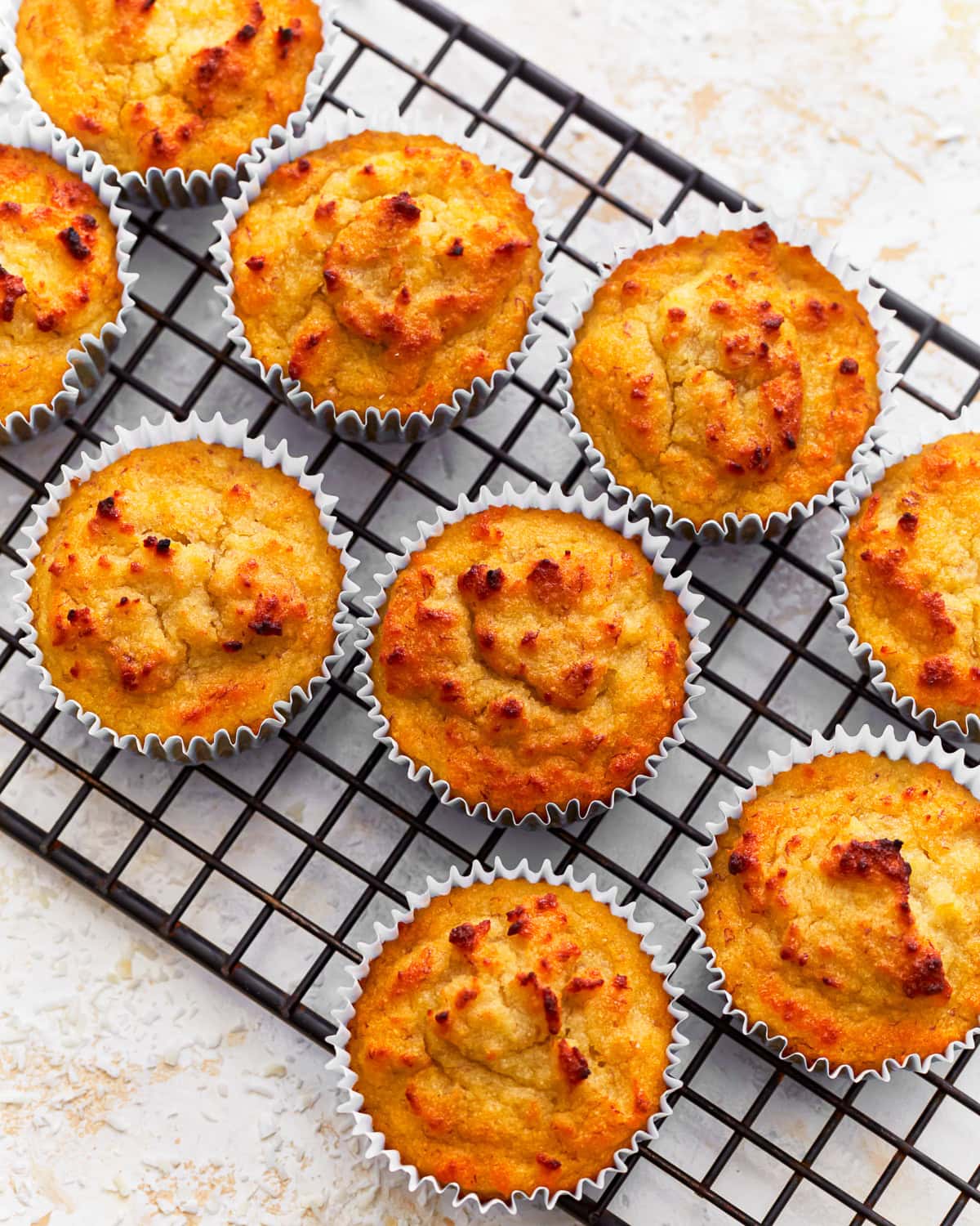 Overhead view of coconut flour muffins on a cooling rack.