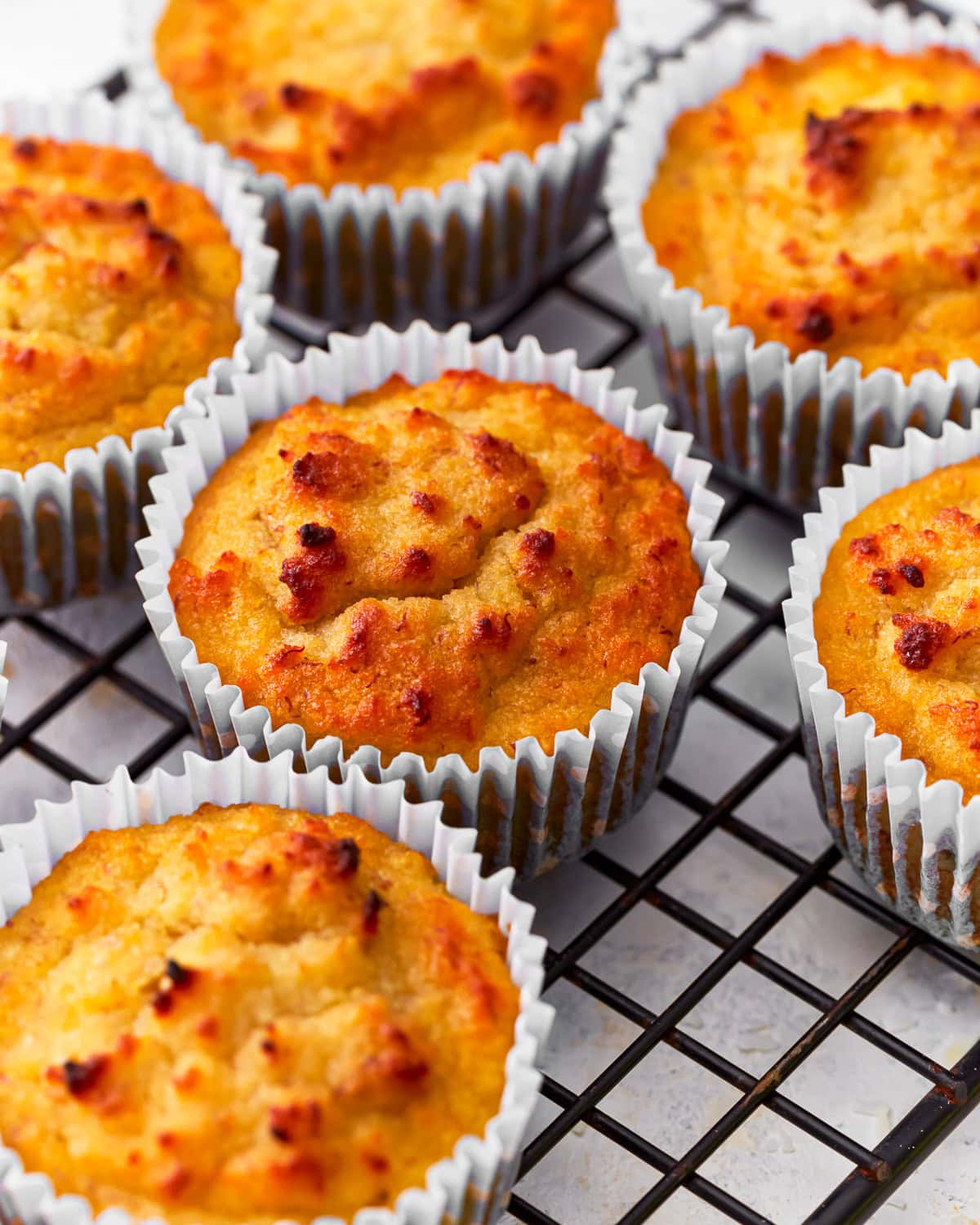 Close up of coconut muffins on a cooling rack.