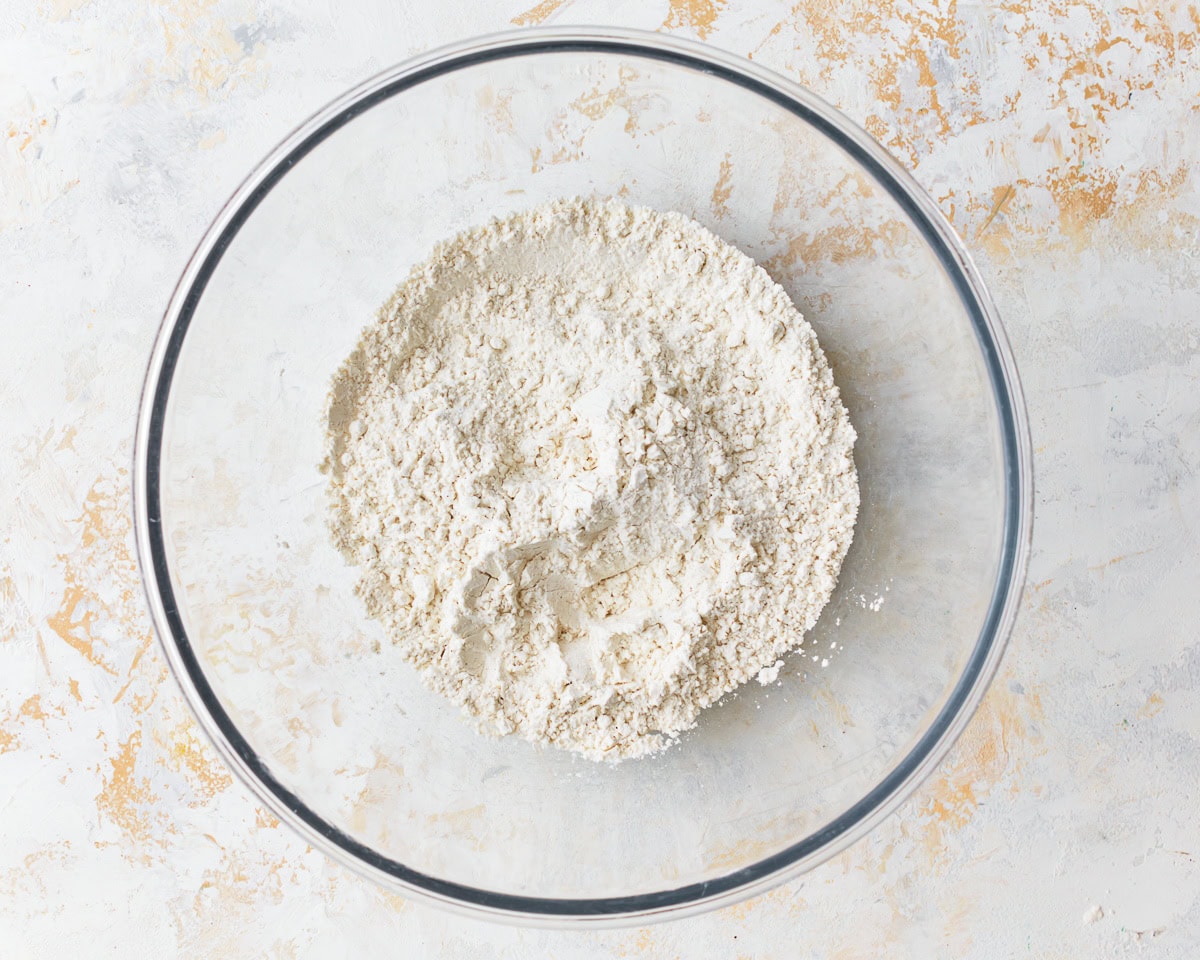 Dry ingredients for gluten-free puff pastry in a glass mixing bowl.