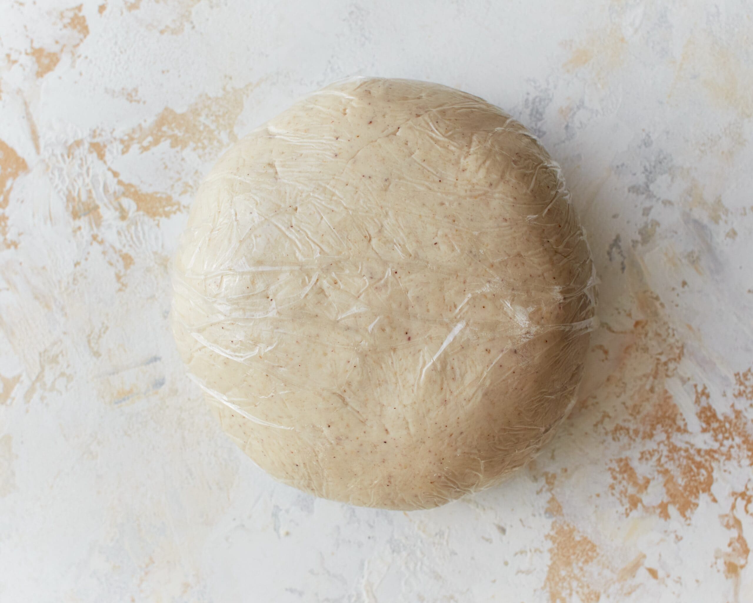 A ball of gluten-free phyllo dough wrapped in plastic wrap.