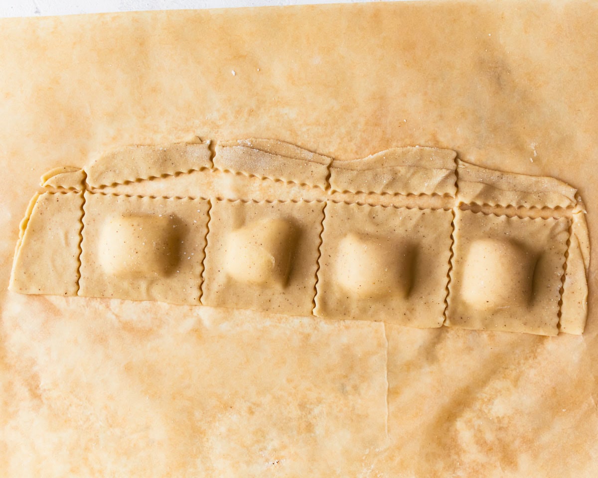 Gluten-free ravioli dough stuffed with filling and cut to shape.