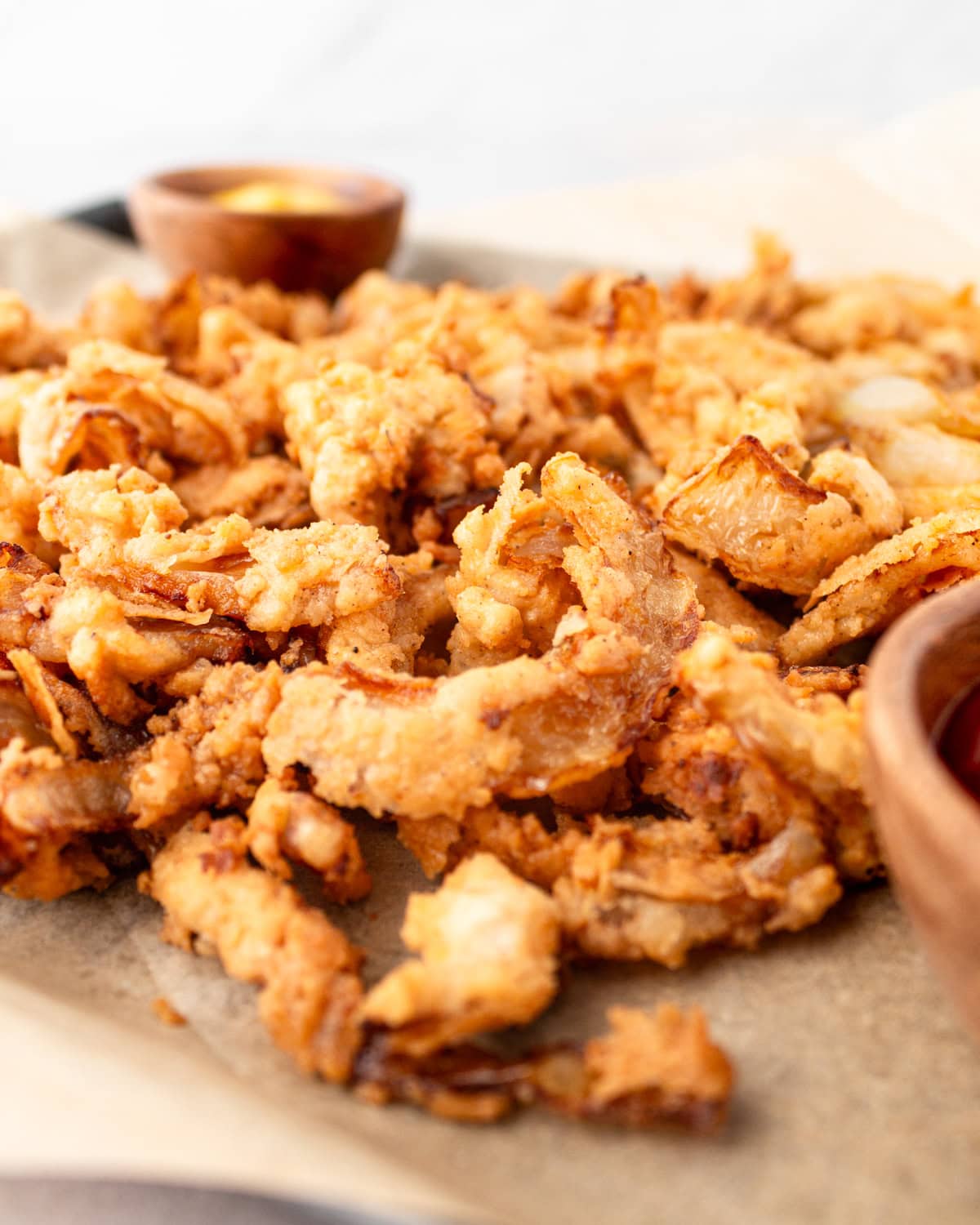 Side view of gluten-free fried onions on a tray.