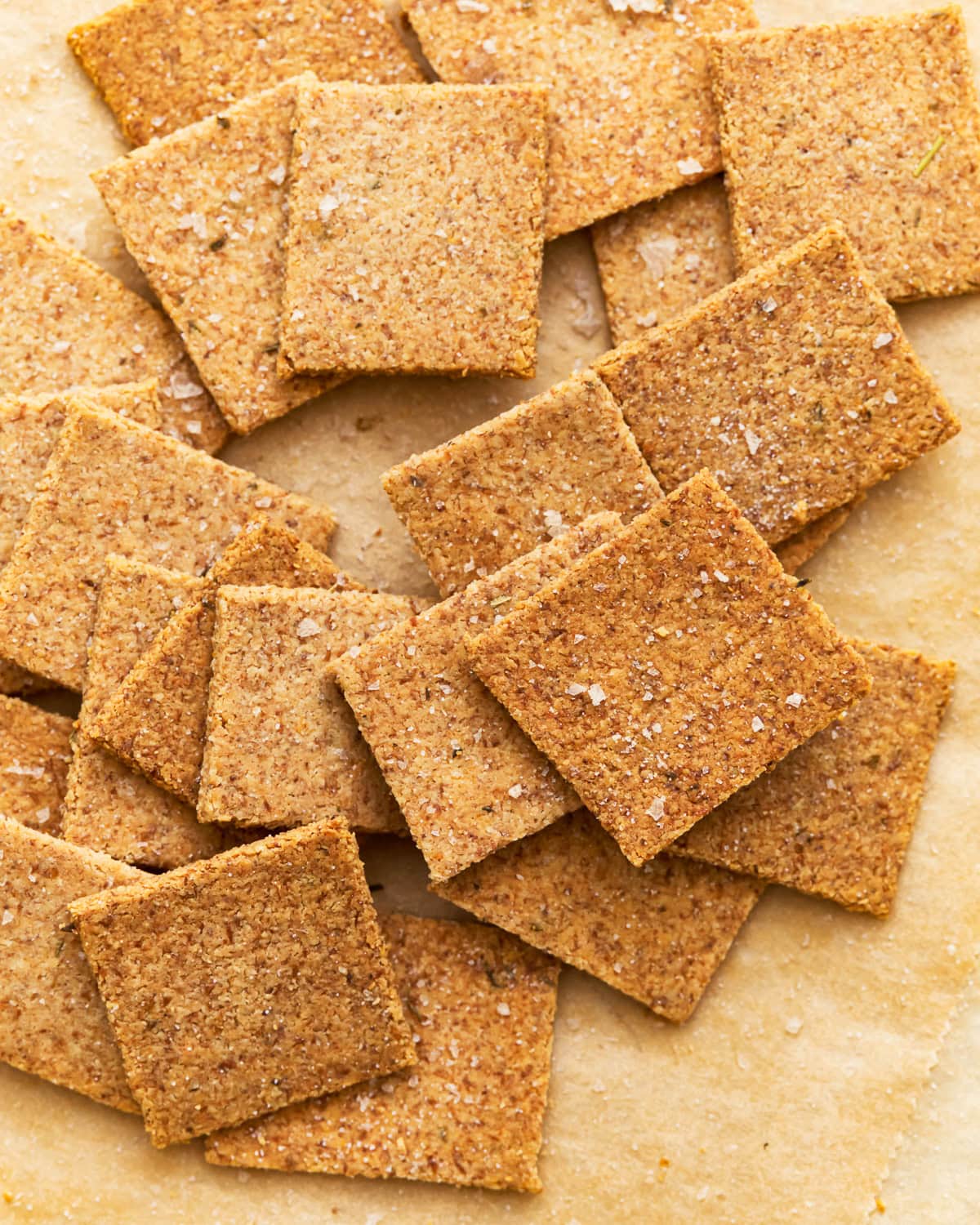 Overhead view of almond flour crackers on parchment paper.