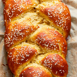 Close up overhead view of gluten-free challah bread topped with sesame seeds.