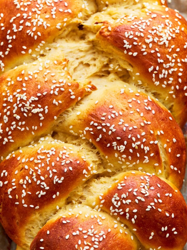 Close up overhead view of gluten-free challah bread topped with sesame seeds.