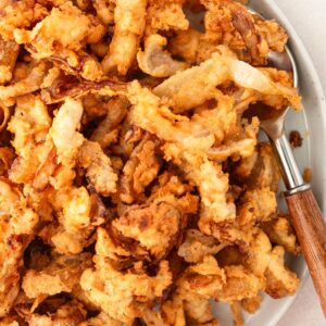 Overhead view of gluten free fried onions in a bowl with a spoon.