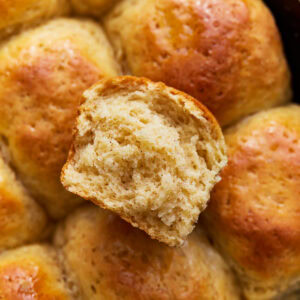 Overhead close up view of gluten-free Hawaiian rolls with one sliced in half.