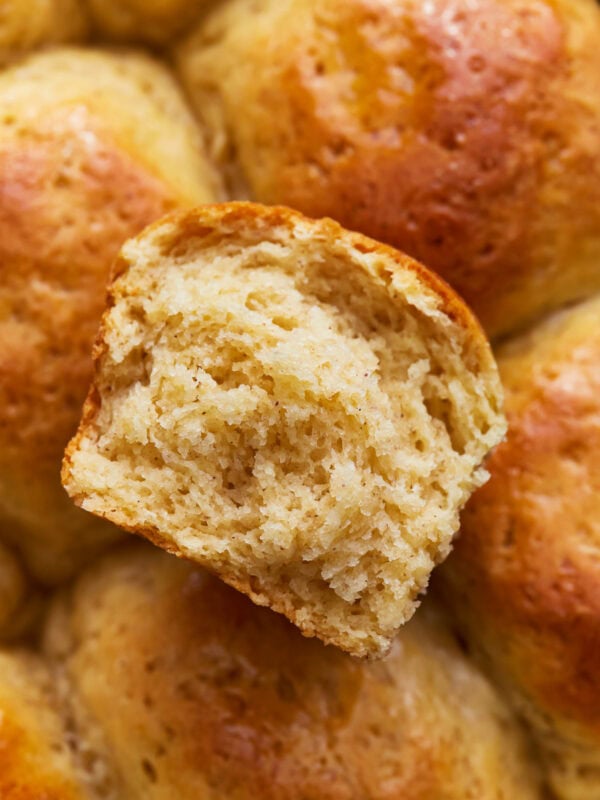 Overhead close up view of gluten-free Hawaiian rolls with one sliced in half.