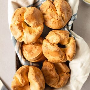 Overhead close up of popovers in a towel lined baking pan.