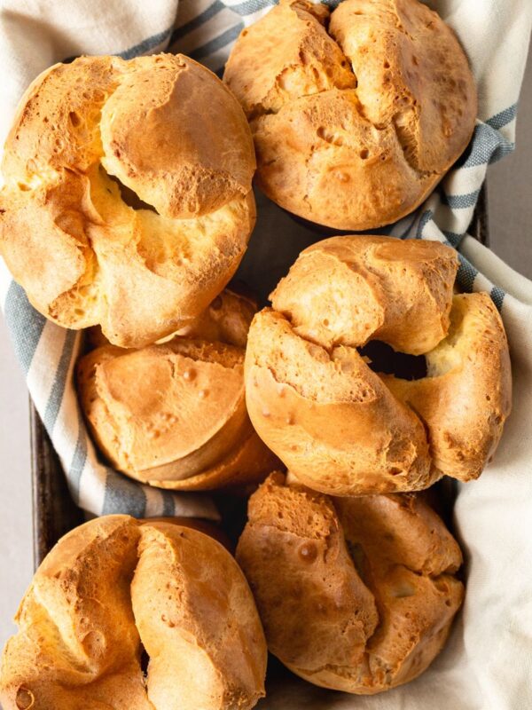 Overhead close up of popovers in a towel lined baking pan.