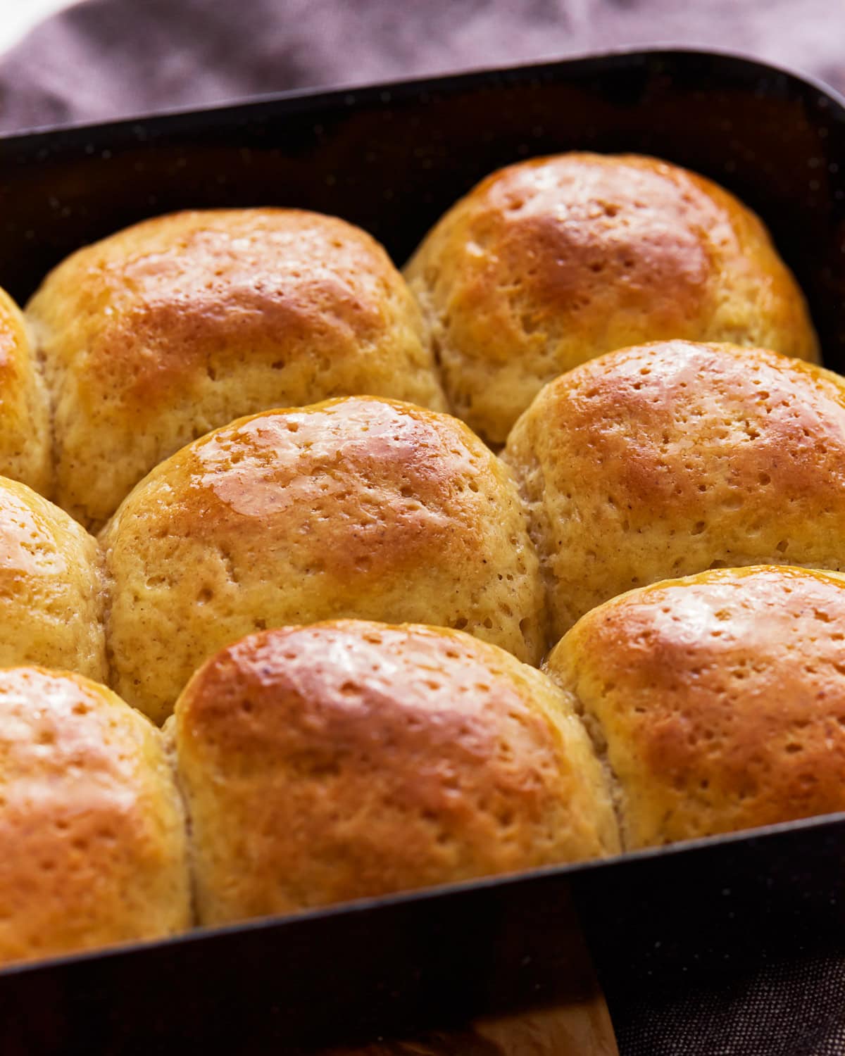 Side view of gluten-free hawaiin rolls in a baking pan.