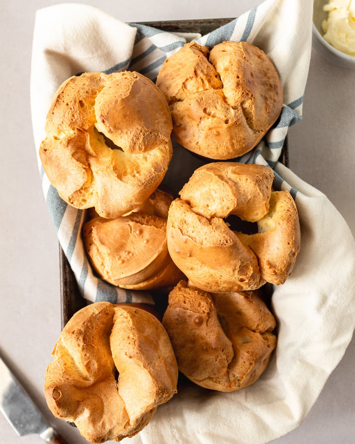 Overhead view of popovers in a towel lined baking pan.