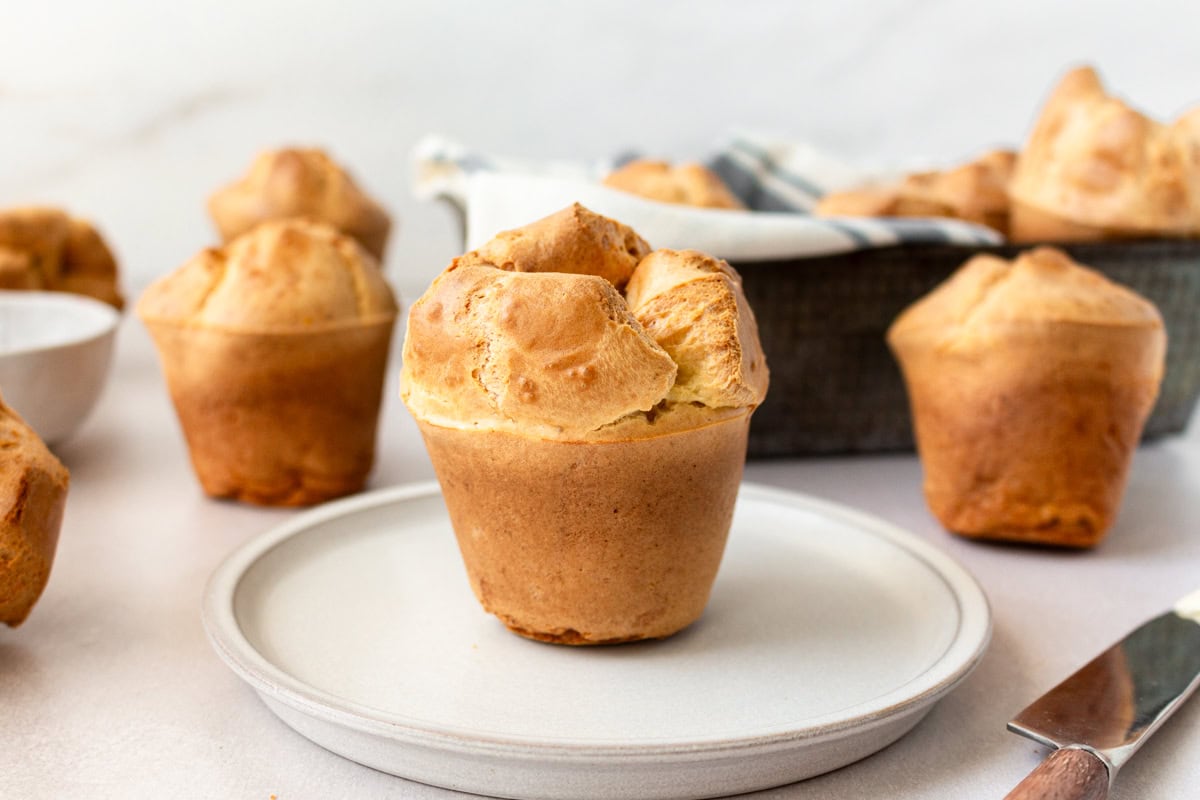 Side view of a gluten free popover on a white plate.