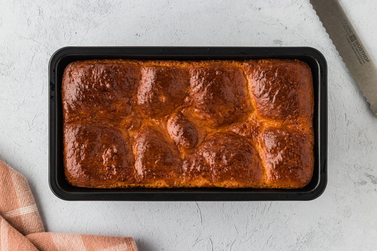 Freshly baked gluten-free brioche bread in a loaf pan.