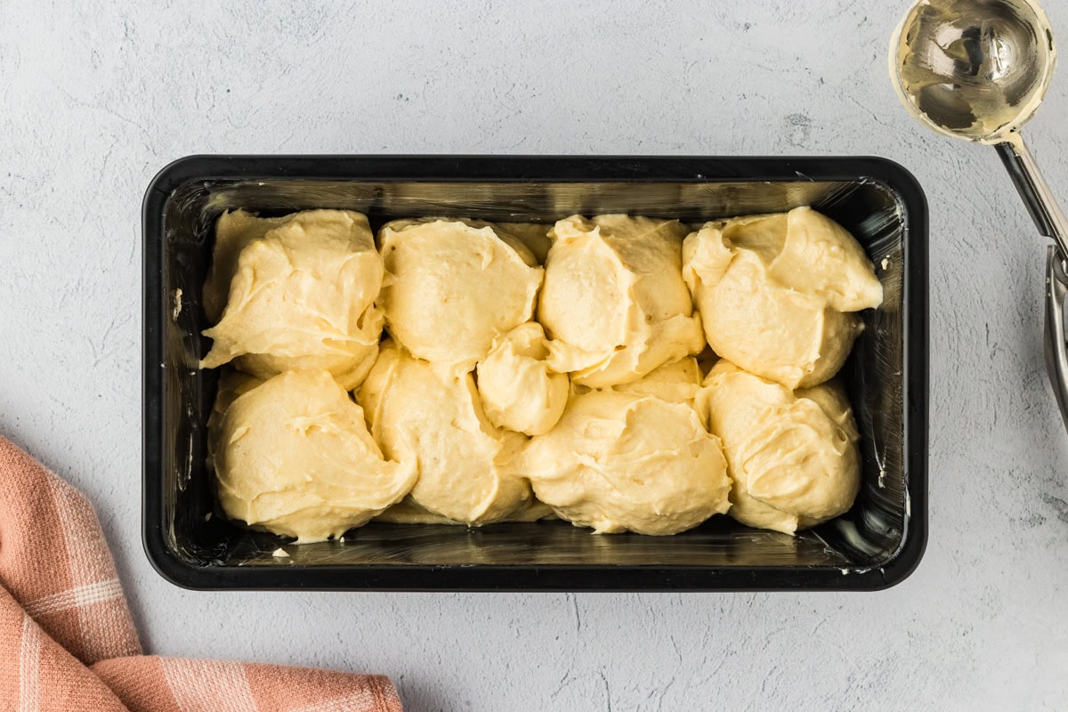 Dollops of gluten-free brioche batter in a loaf pan.