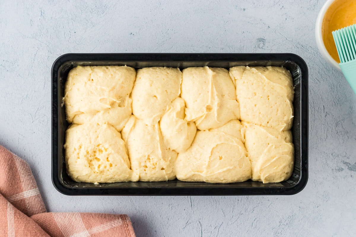 Proofed gluten-free brioche dough in a loaf pan.