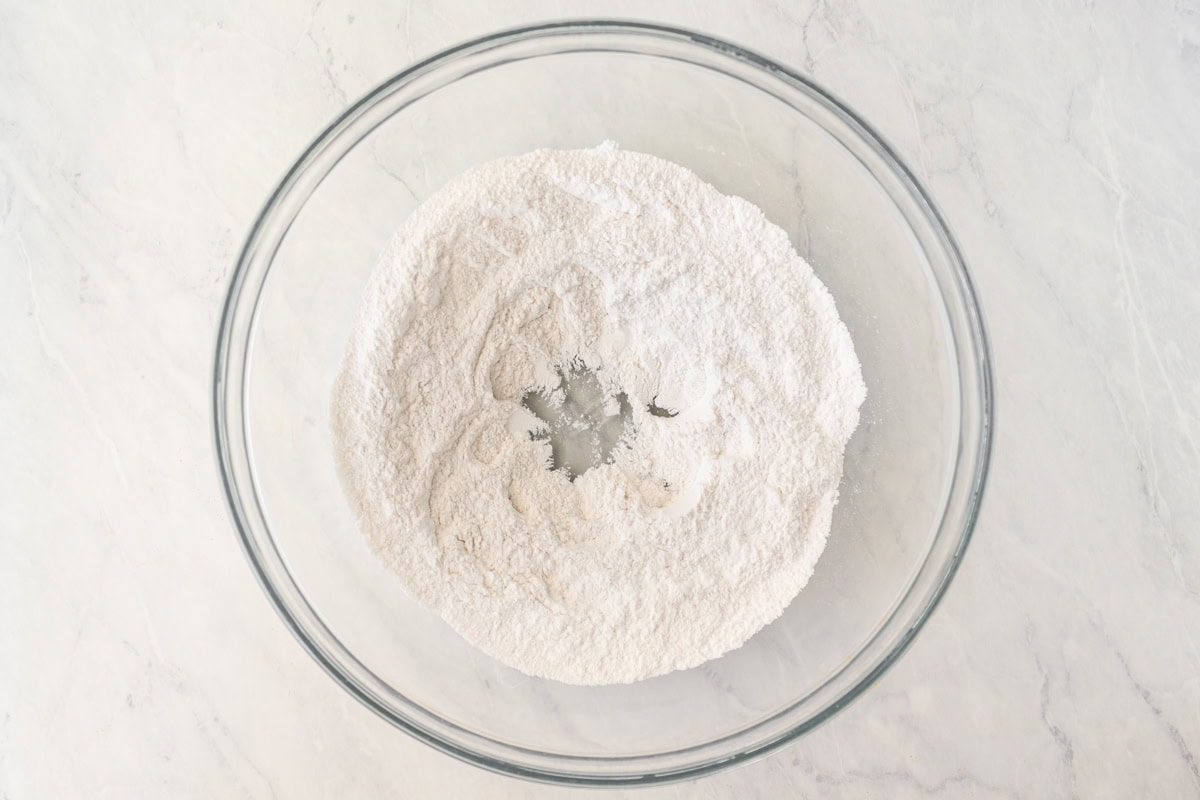 Dry ingredients for gluten-free wonton wrappers in a glass mixing bowl.