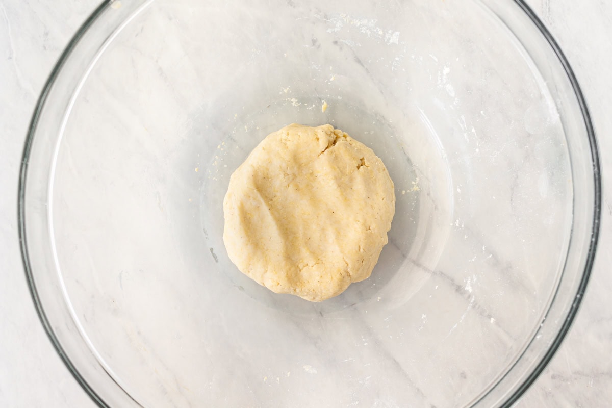 A ball of gluten-free wonton wrapper dough in a glass mixing bowl.