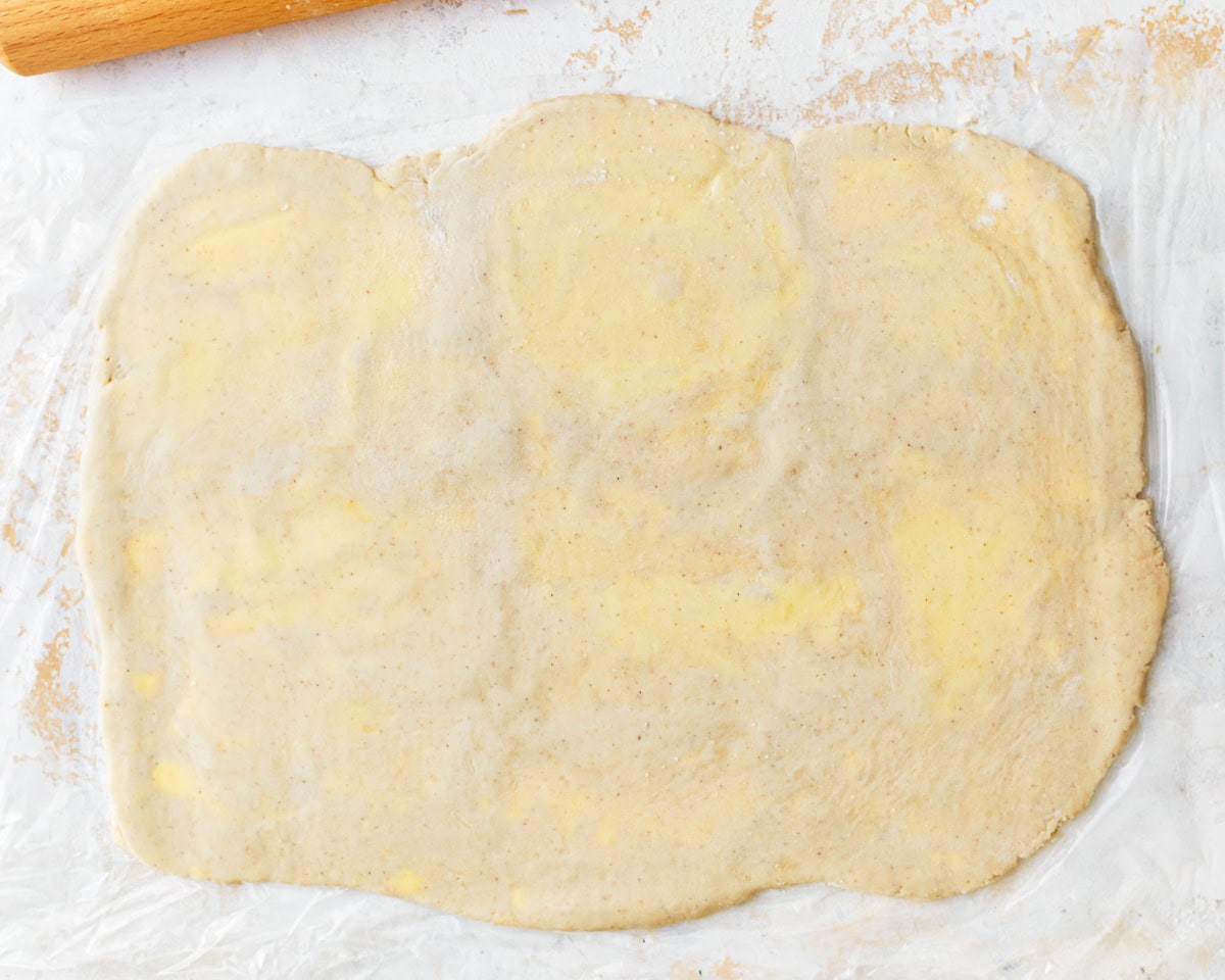 Rolled out puff pastry dough with flecks of butter throughout.