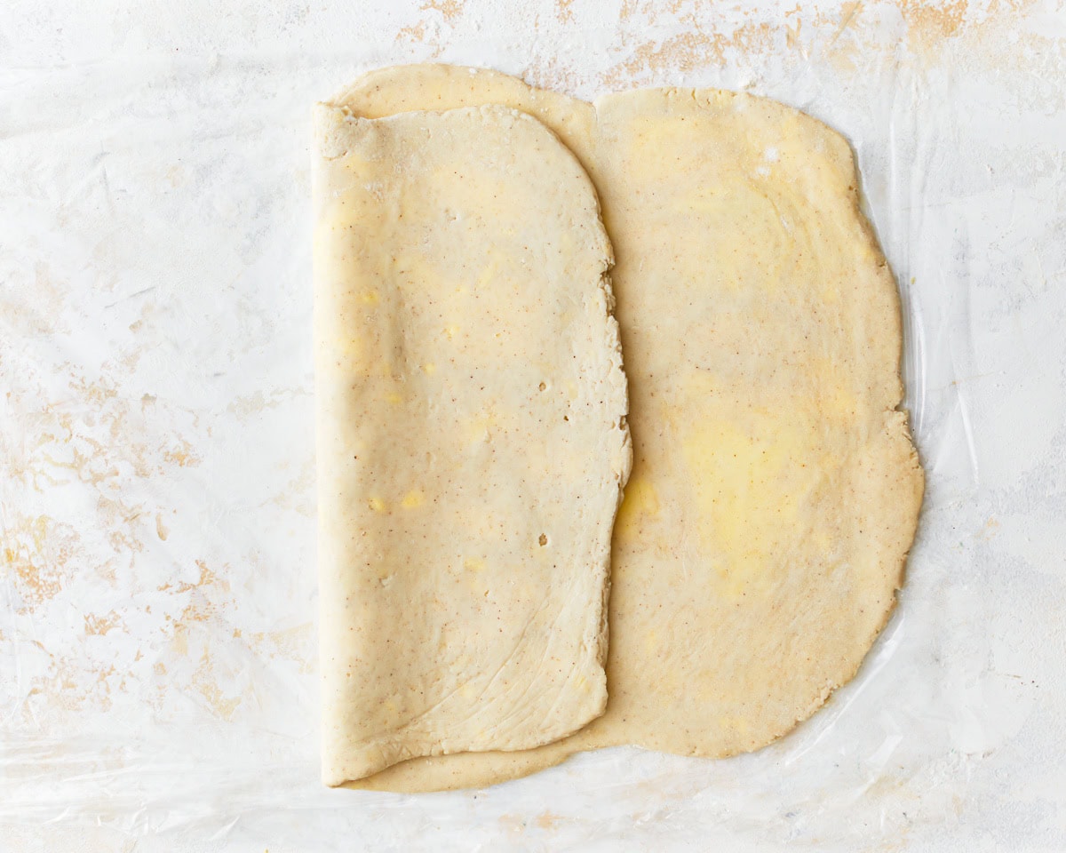 Gluten-free puff pastry dough folded halfway onto itself.