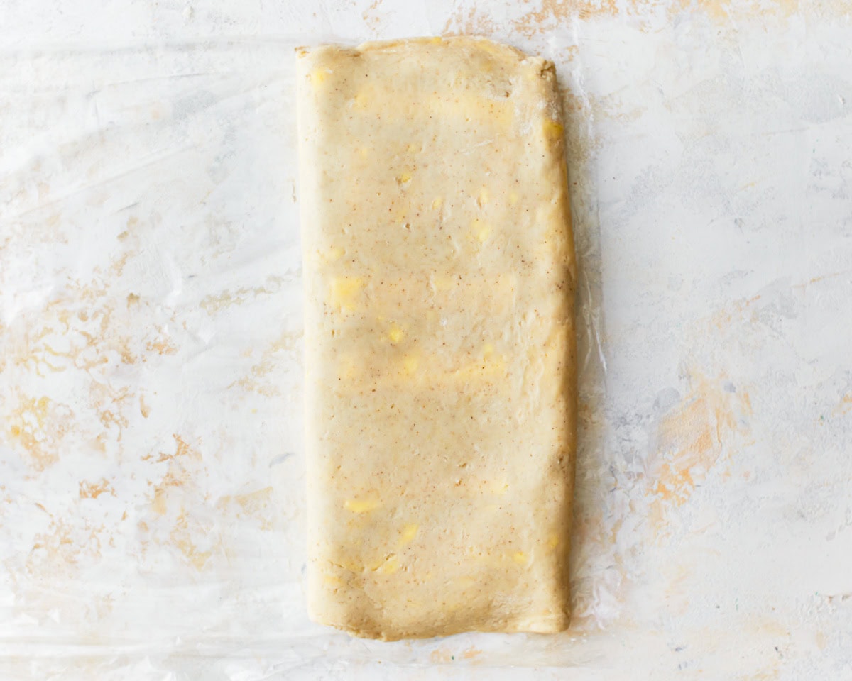 Gluten-free puff pastry dough folded into a rectangle with flecks of butter throughout.