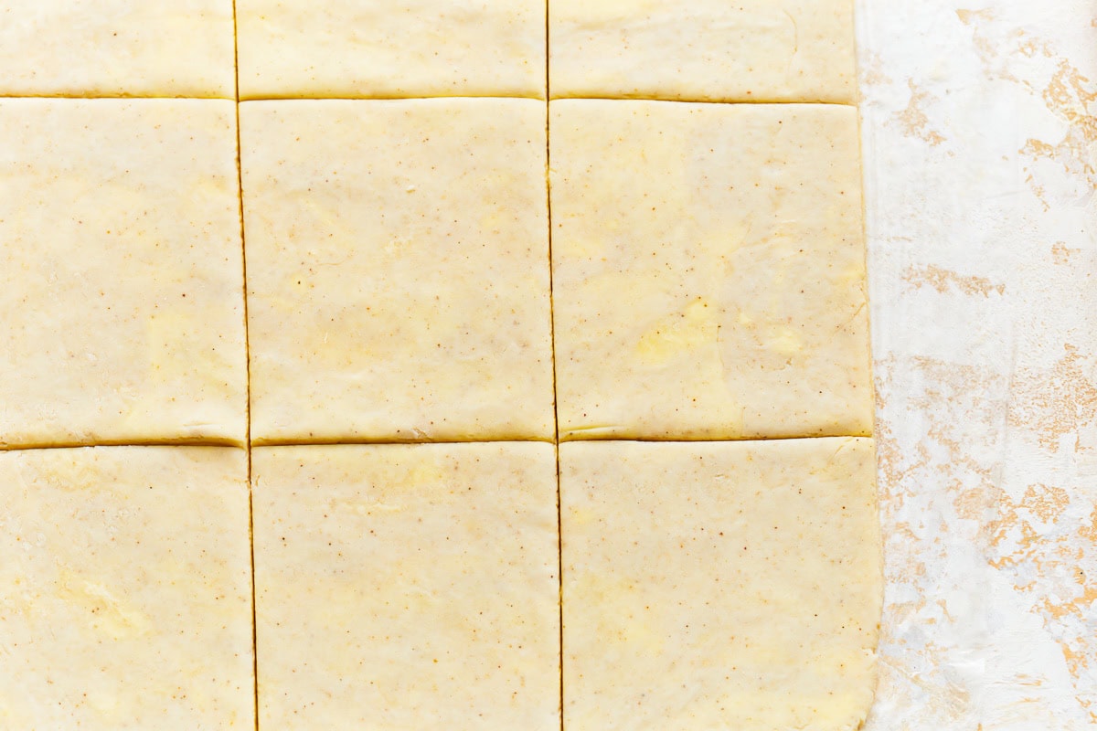 Close up of gluten-free puff pastry dough cut into squares.