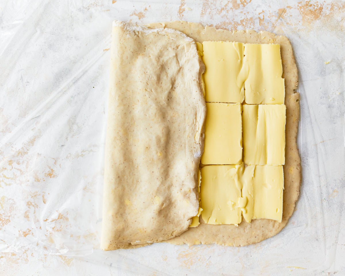 Rolled out gluten-free puff pastry dough folded over sliced butter.