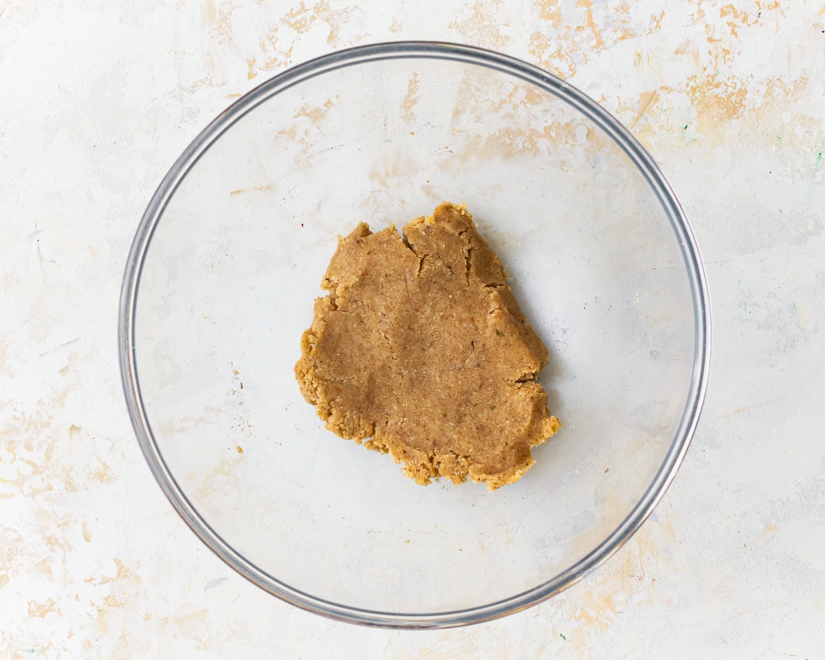 Almond flour cracker dough in a glass mixing bowl.