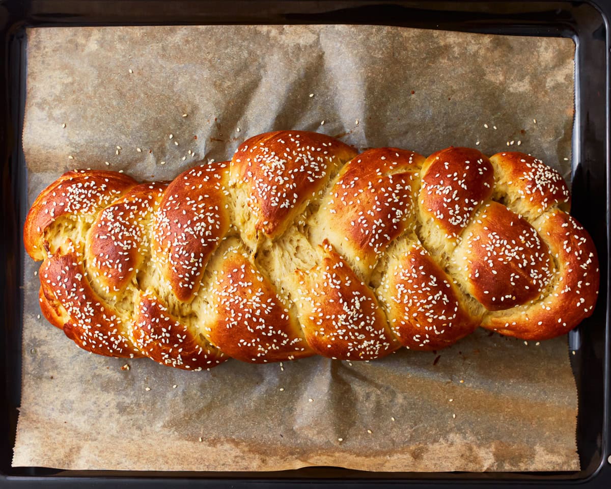 Freshly baked gluten-free challah bread on a parchment lined baking tray.