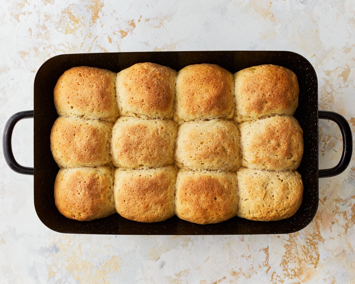 Freshly baked gluten-free hawaiian rolls in a baking pan.